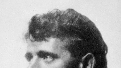 A black and white photo of a man in a tie, with a philosophical air.