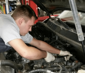 An automotive technician repairing a car engine.