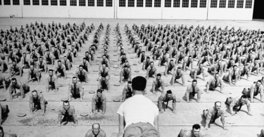 A man is demonstrating essential leadership qualities to a large group of people.