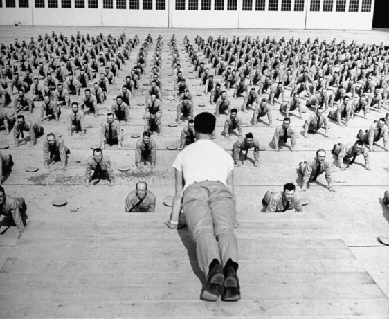 Vintage army military squad doing push ups.