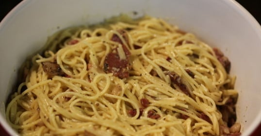 A bowl of spaghetti carbonara with bacon.