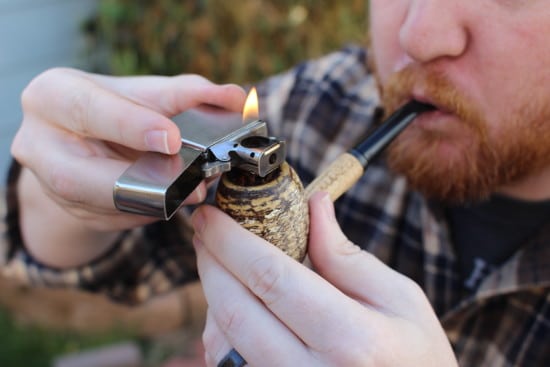 Lighting tobacco corn cob pipe zippo lighter. 