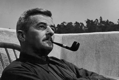 A man sitting in a chair enjoying his pipe.