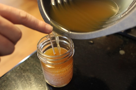 Liquid wax pouring in small vessel.