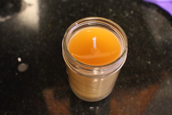 Simple candle in a vessel displayed on table.