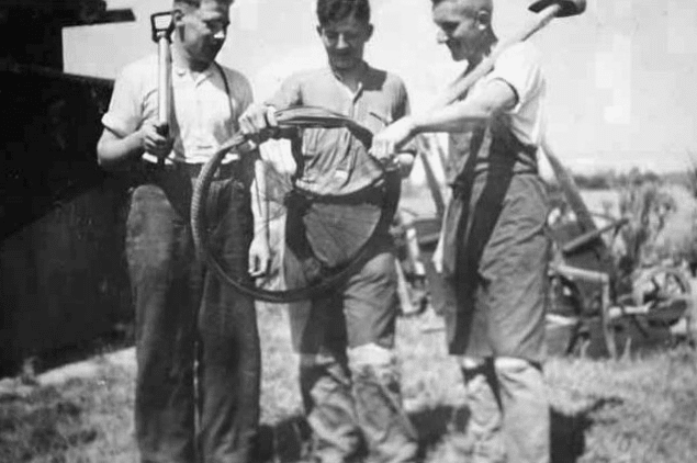 Men's holding a tire in their hands.