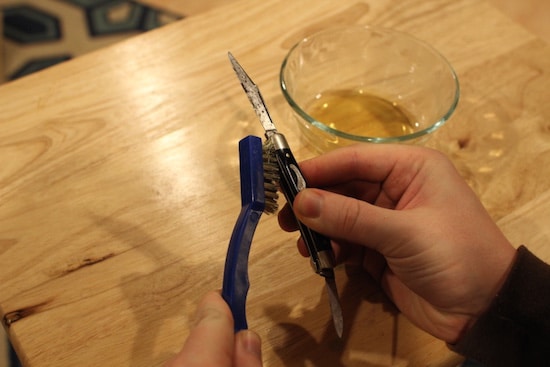 Restore antique vintage pocket knife using scrubbing brass brush.