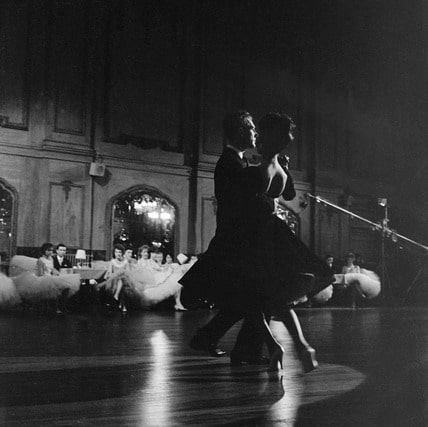 Vintage couple ballroom dancing large hall.