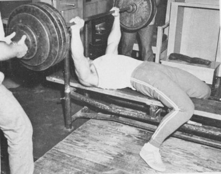 Vintage man doing bench press weightlifting.