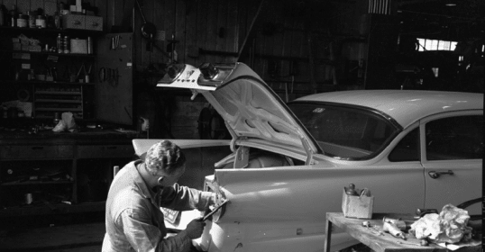 An honest mechanic working on a car in a garage.