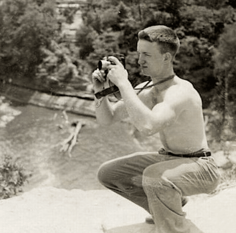 Vintage man kneeling shirtless taking photographs photos.