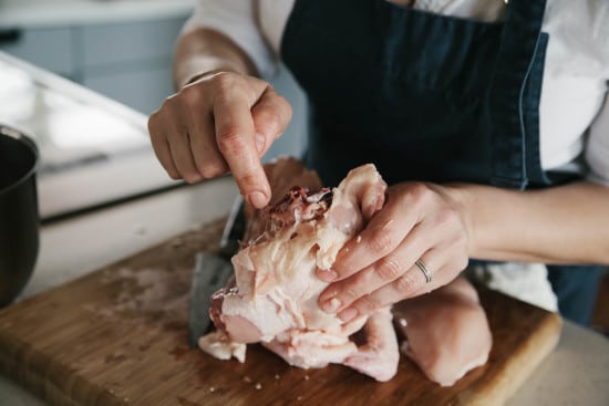 Chef Sarah is breaking spine back bone of chicken.