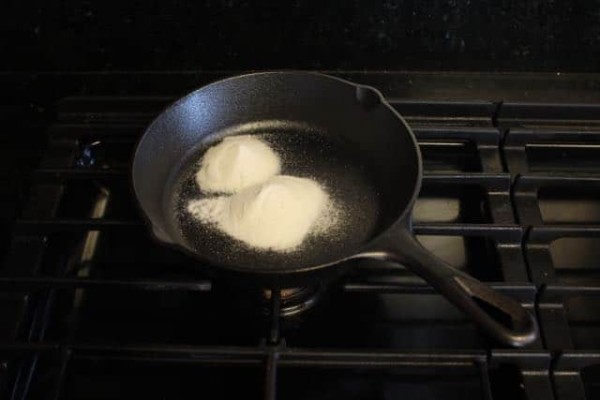 Diy smoke bomb mixing sugar and potassium nitrate in a pan on a stove. 