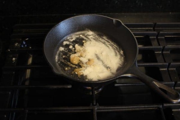 Diy smoke bomb brown goo forming in a pan on a stove. 