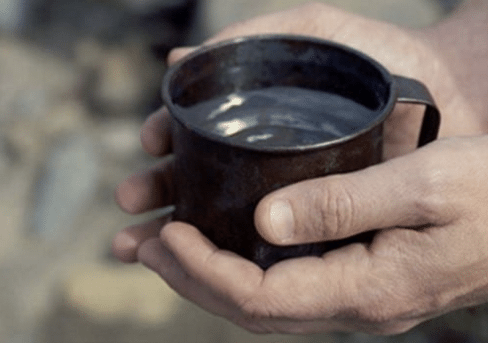 A man's hands holding a mug of water, experiencing a simple miracle.