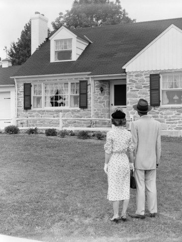Couple are standing in yard for looking at home.