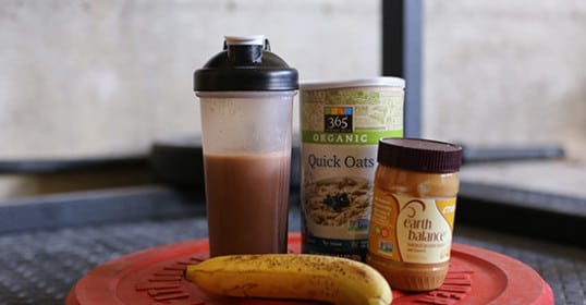 A banana and peanut butter on a red plate, perfect for pre-workout energy boost.