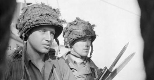 Two soldiers in active readiness with rifles standing next to each other.