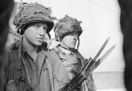 Two soldiers in active readiness with rifles standing next to each other.
