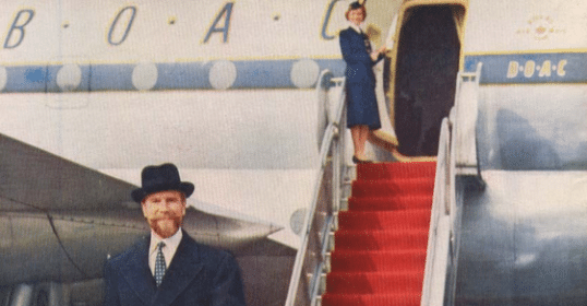 A man in a suit walking down a red carpet for a job.