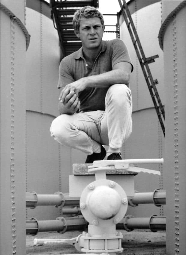 steve mcqueen squatting sitting on navy ship