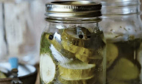 Pickles in mason jars on a table, perfect for recipes or pickling enthusiasts.