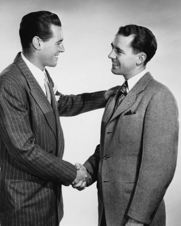 Two men smiling while shaking hands.