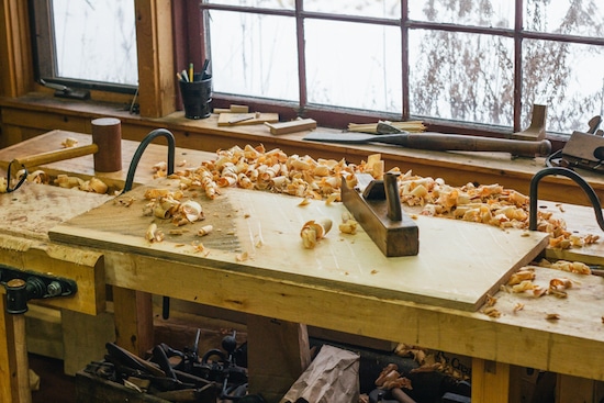 Lumber in workshop with hand plane.