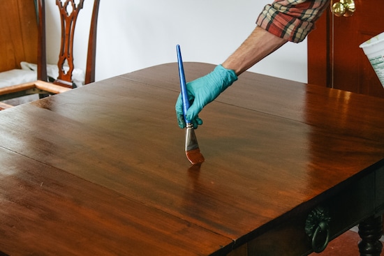 Finishing handmade wood table with stain.