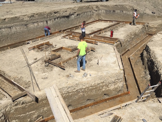 Group of men making foundation for a building.