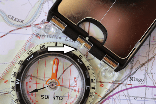 Taking a bearing with map and compass close up photo.