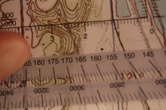 Land navigation protractor lined up on topo topographic map.