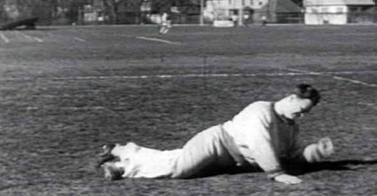 A vintage photograph of a man lying on the ground.