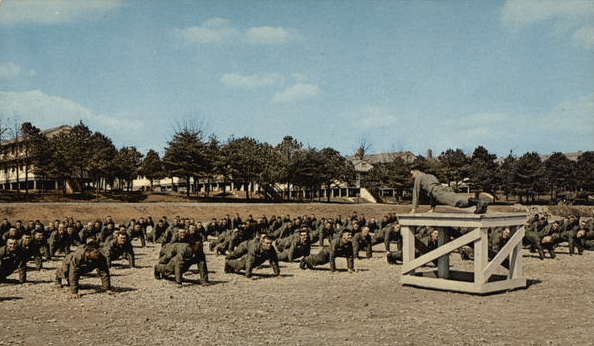 Vintage army boot camp soldiers doing push ups.