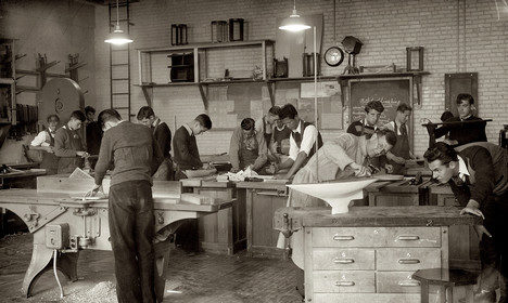 A group of high school students honing their skills in a wood shop.