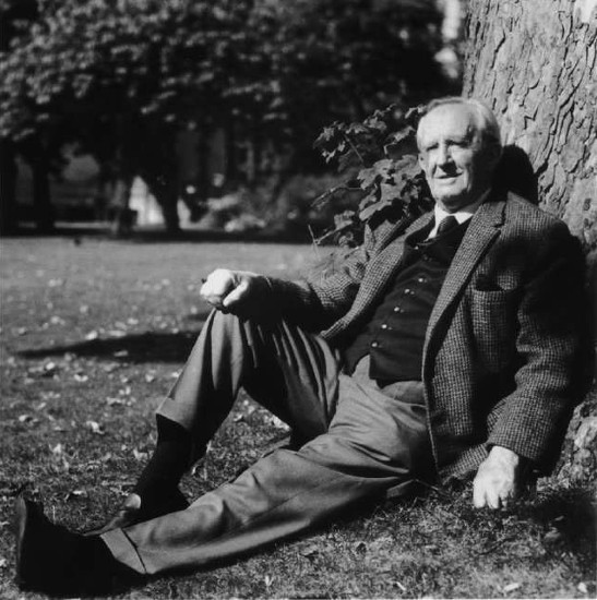 A man in a suit sitting under a tree, embracing the Cult of Travel.