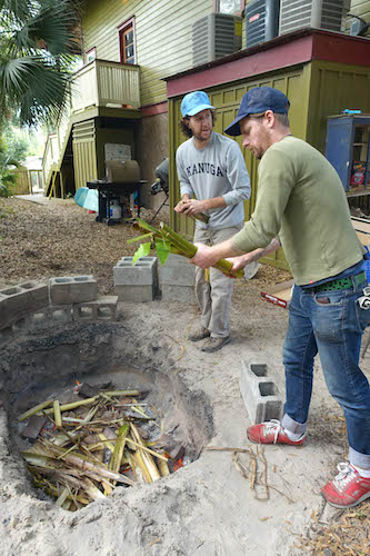 Men adding soil for looking spots on pig meat.