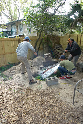 Men lowering the pig with the help of imu into hole digger.