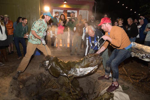 Men taking out the pig from the imu.