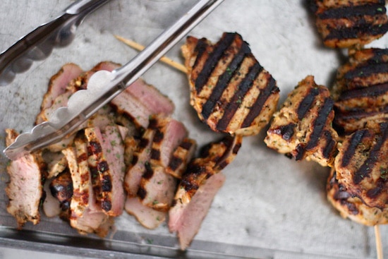 Grilling pork tenderloin on skewers.