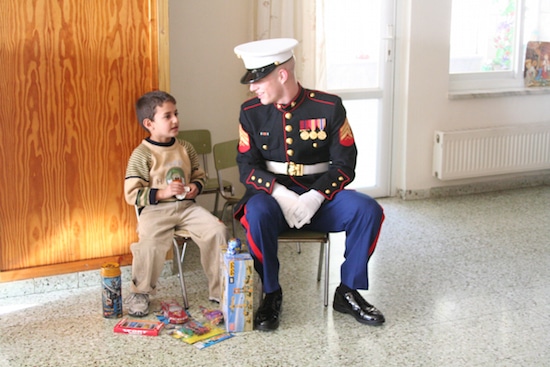 Little boy talking with Marine embassy guard.