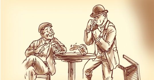 Two men sitting at a table, engaging in conversation while talking on the phone.