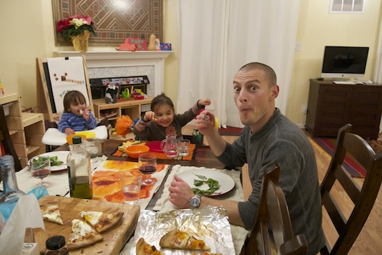 A family enjoys pizza together at the table.