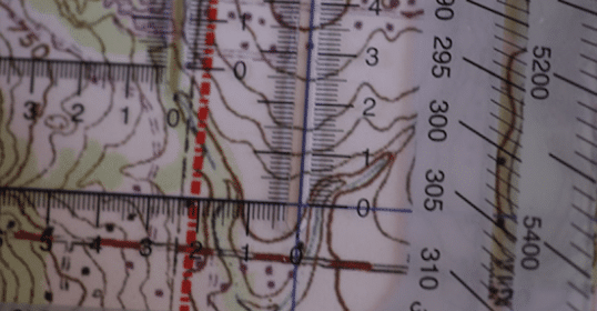 A close up of a map with a ruler used for Military Grid Reference System navigation.