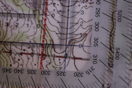 A close up of a map with a ruler used for Military Grid Reference System navigation.
