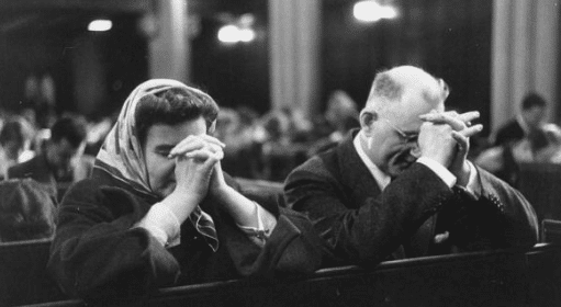 vintage couple praying in church pew kneeling