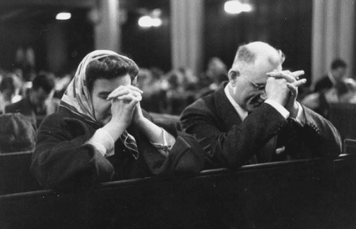 vintage couple praying in church pew kneeling