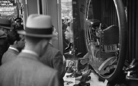 A man in a hat browsing shoes in a store.