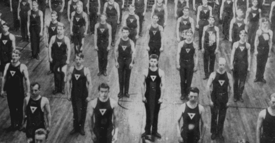 A black and white photo of a muscular group of men.