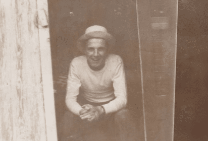 An old photo of a man sitting.
